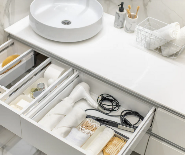 Open drawer with bathroom items next to a sink